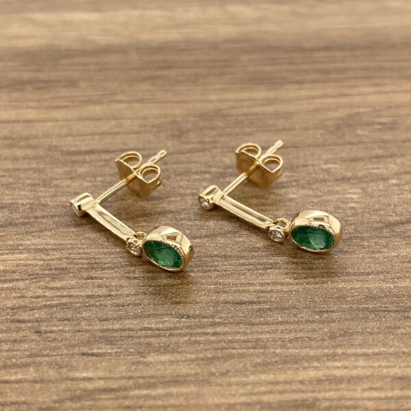 Gold emerald and diamond earrings.