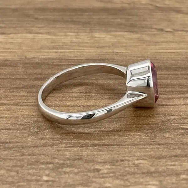 Silver ring with pink gemstone.