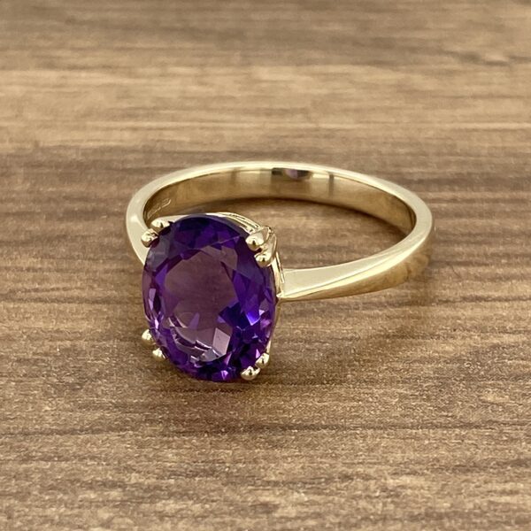 Gold ring with a purple amethyst stone.