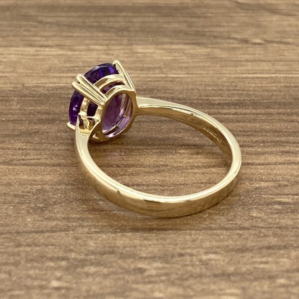 Gold ring with a large purple stone.