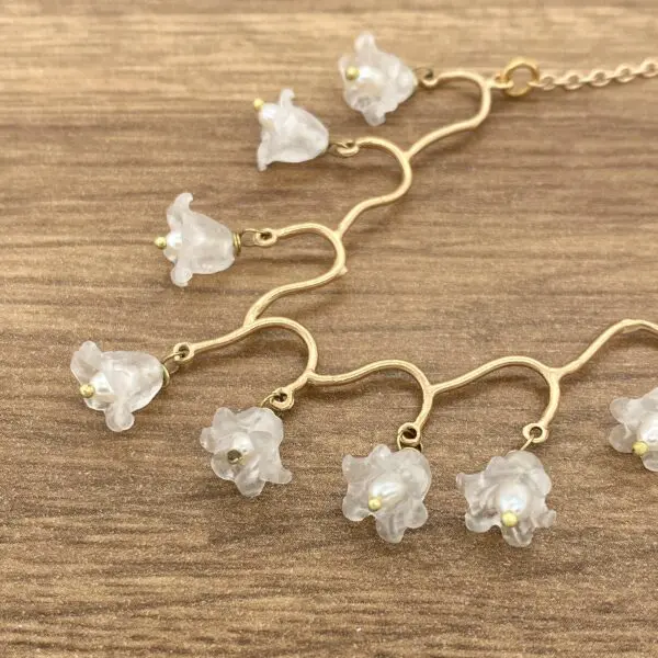 Gold necklace with white flower charms.