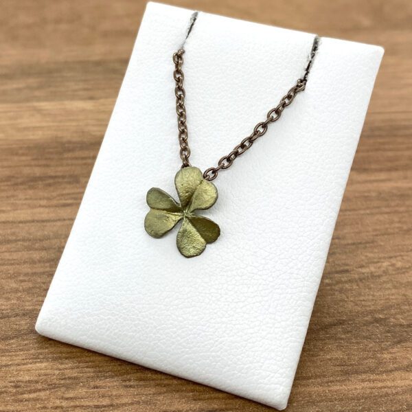 Gold four-leaf clover necklace on display.