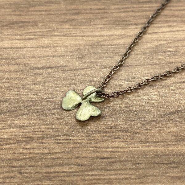 Gold chain necklace with shamrock pendant.