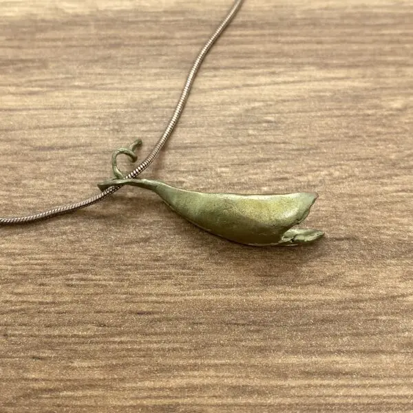 Gold chain with a pea pod pendant.