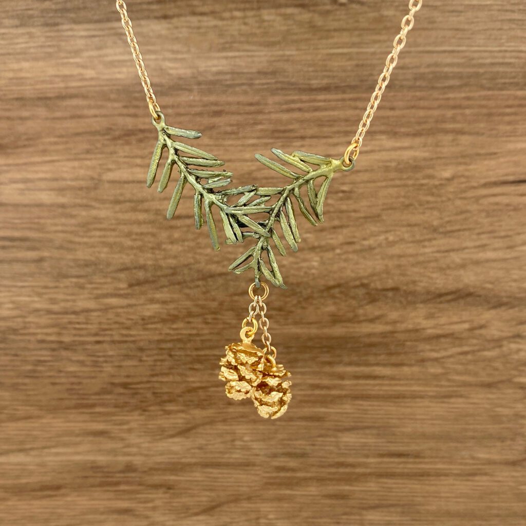 Gold pine cone pendant necklace.