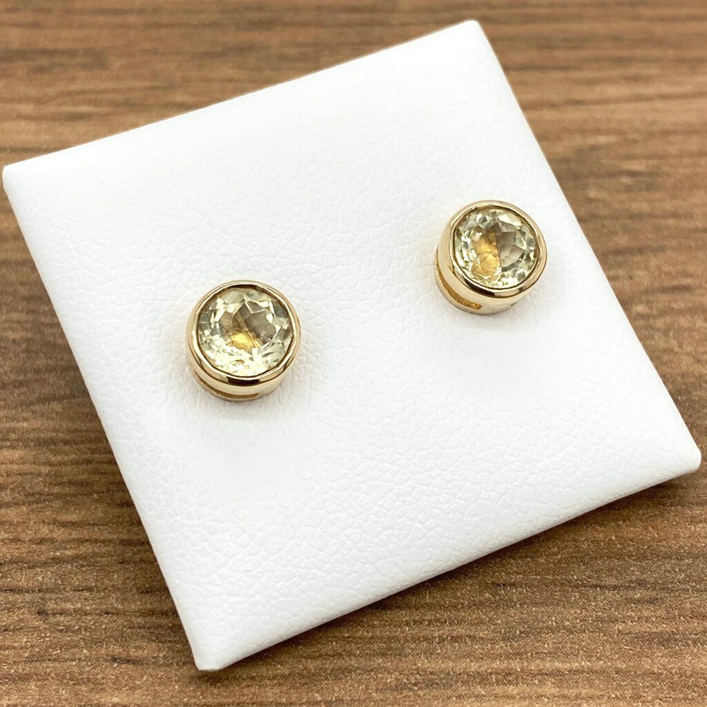 Gold earrings with yellow gemstones.