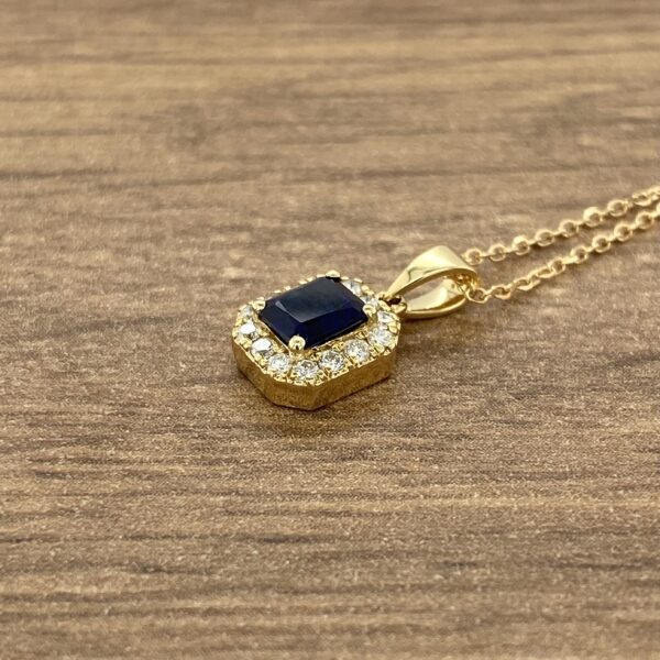 Gold necklace with blue sapphire pendant.