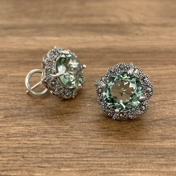 Silver earrings with green gemstones.