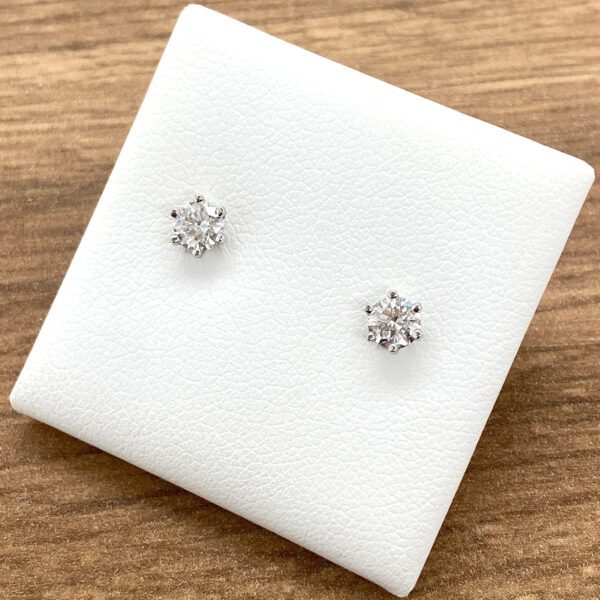 Diamond earrings on white display card.