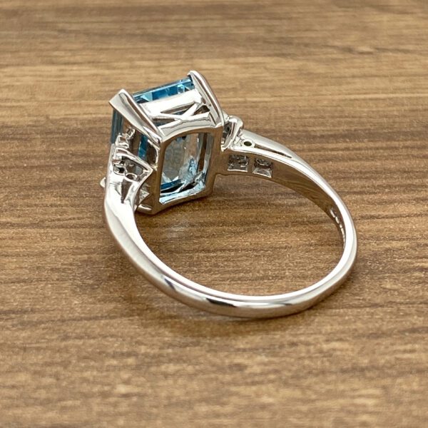 Silver ring with blue gemstone and diamonds.