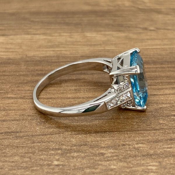 Silver ring with large blue gemstone and diamonds.