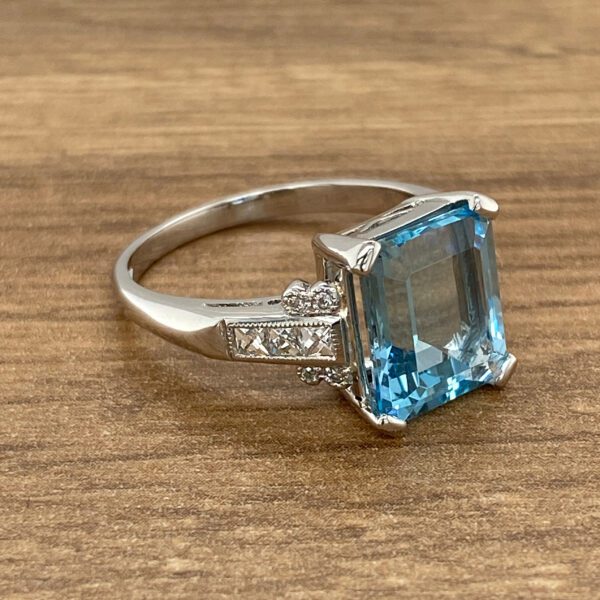 Silver ring with blue gemstone and diamonds.