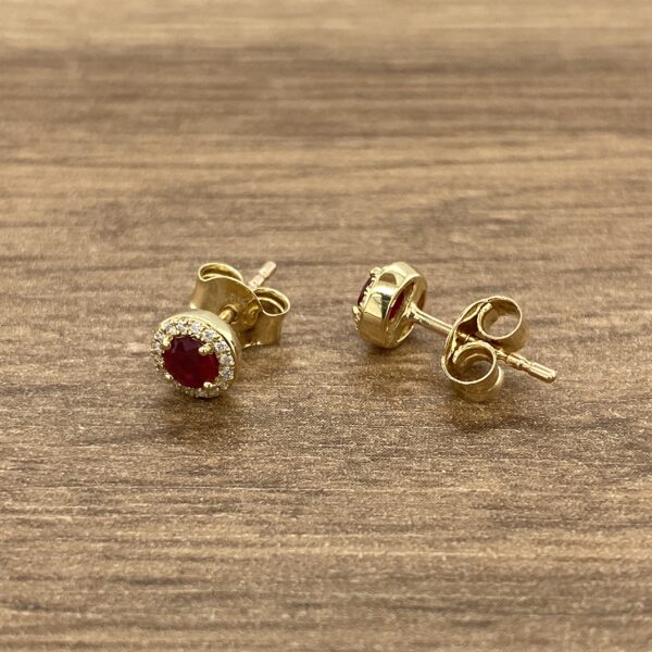 Gold earrings with ruby and diamond accents.