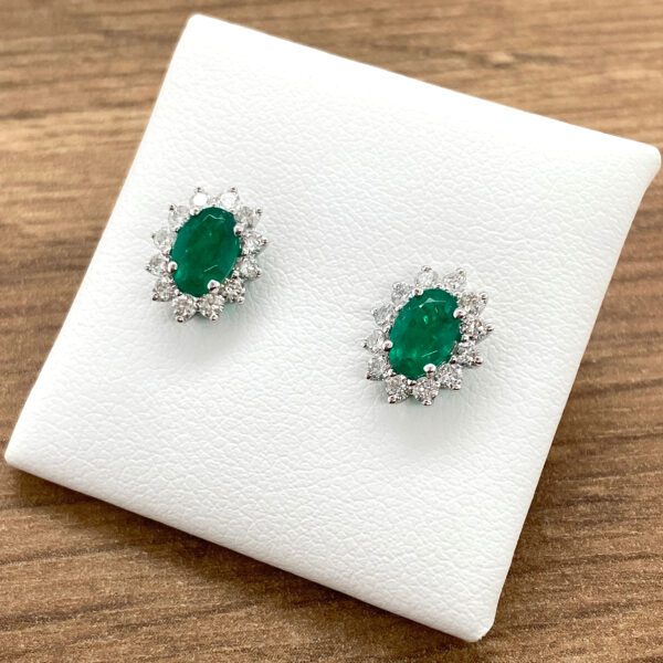 Emerald and diamond halo earrings.