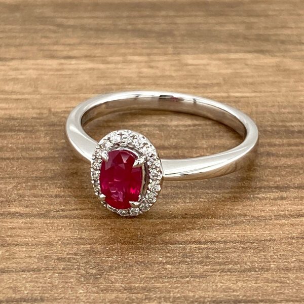 Oval ruby ring with diamond halo.