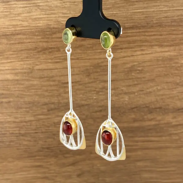 Silver and gold dangle earrings with red and green stones.