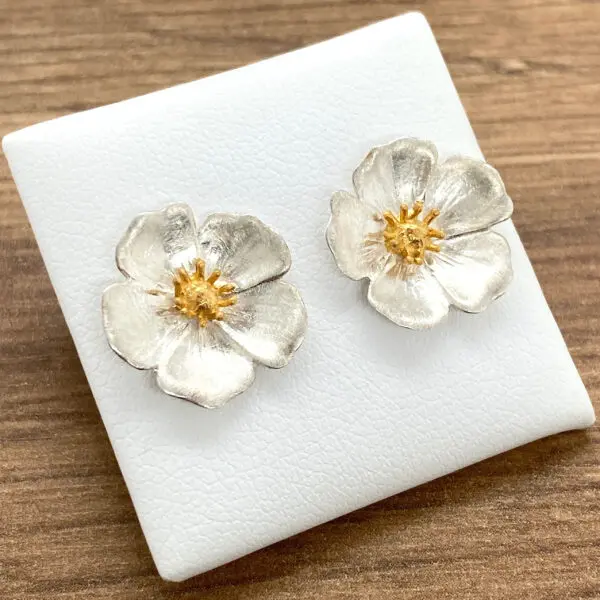 Silver and gold flower stud earrings.