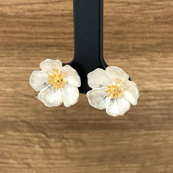 Silver flower earrings with gold centers.