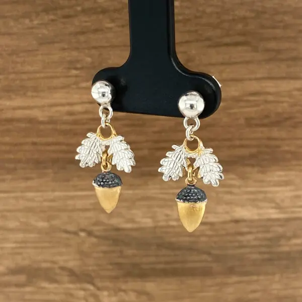 Gold and silver acorn earrings with leaves.