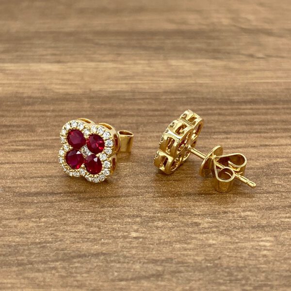 Gold earrings with ruby and diamond accents.