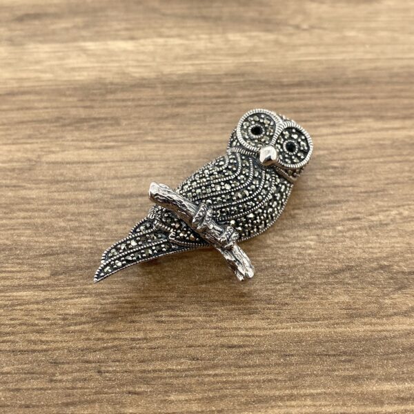 Silver marcasite owl brooch on branch.