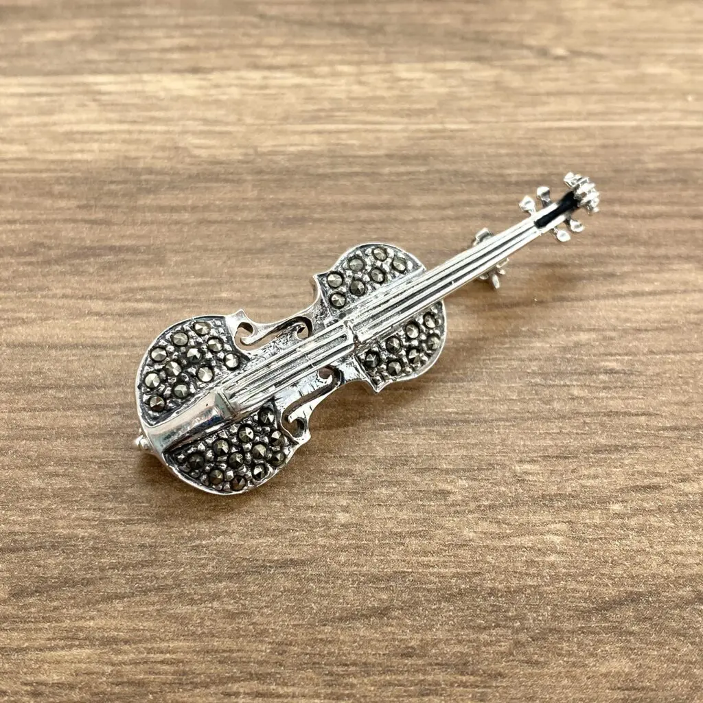 Silver violin brooch with marcasite stones.