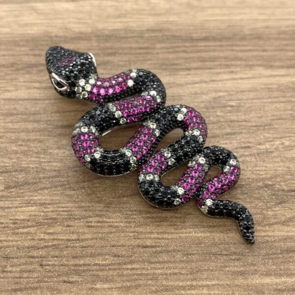 Black and pink jeweled snake pendant.