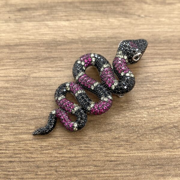 Black and pink jeweled snake brooch.