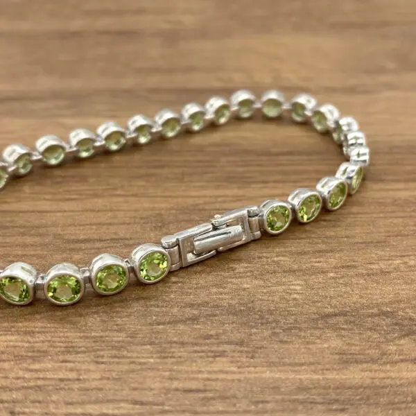 Silver bracelet with green gemstones.