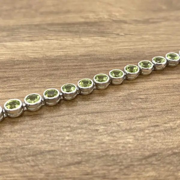 Silver bracelet with green gemstones.