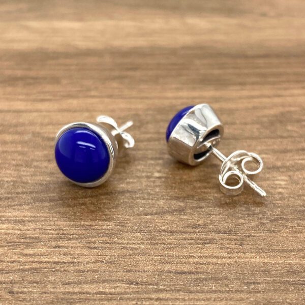 Silver earrings with blue gemstone studs.