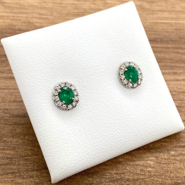 Emerald and diamond halo stud earrings.