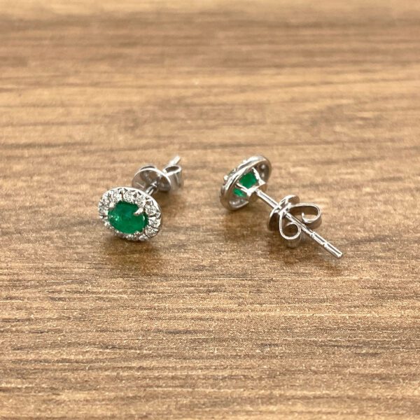 Emerald and diamond halo stud earrings.