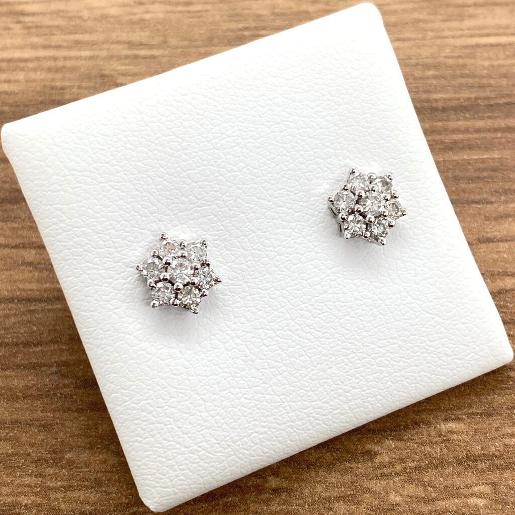 Diamond flower stud earrings on display.