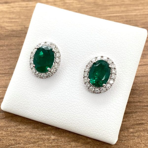 Emerald and diamond halo stud earrings.