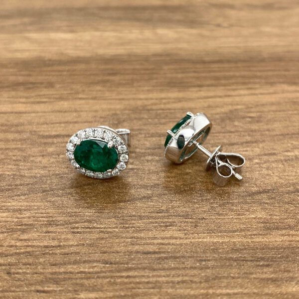 Emerald and diamond halo stud earrings.