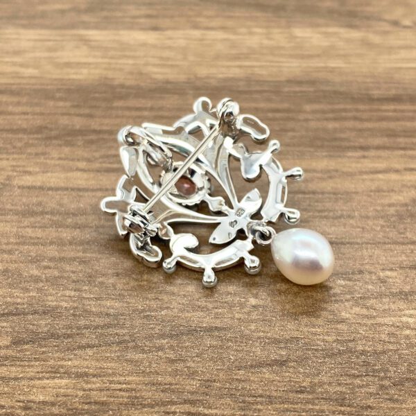 Silver brooch with pearl and stone.