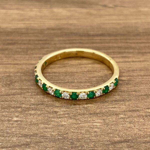 Gold emerald and diamond eternity band.