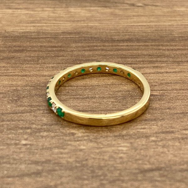 Gold emerald and diamond eternity band.