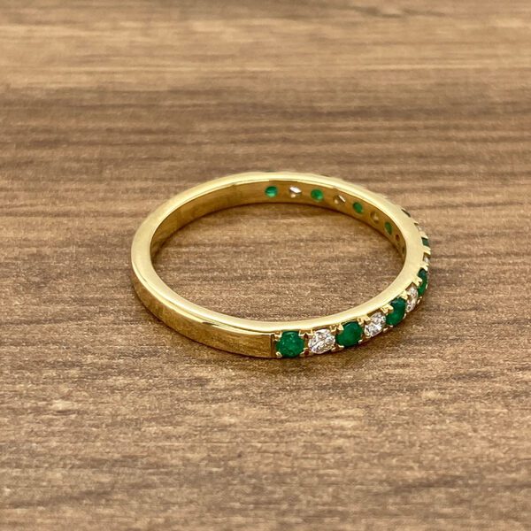 Gold emerald and diamond band ring.