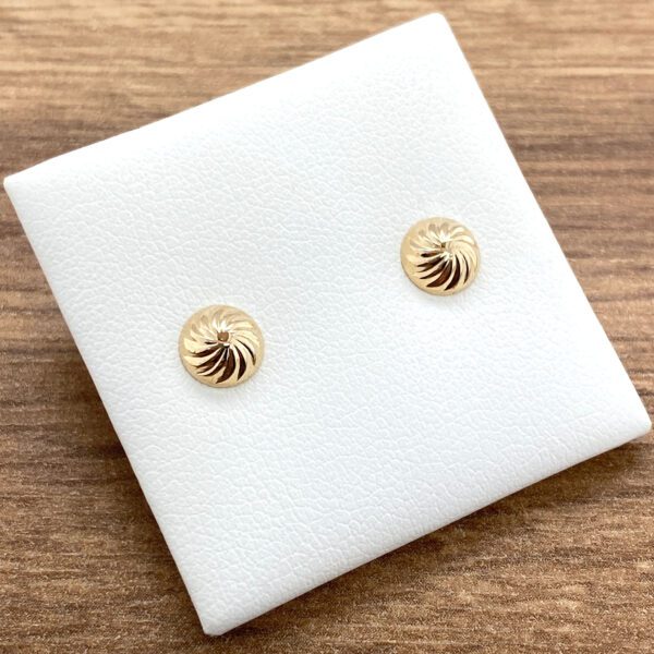 Gold swirl stud earrings on display.