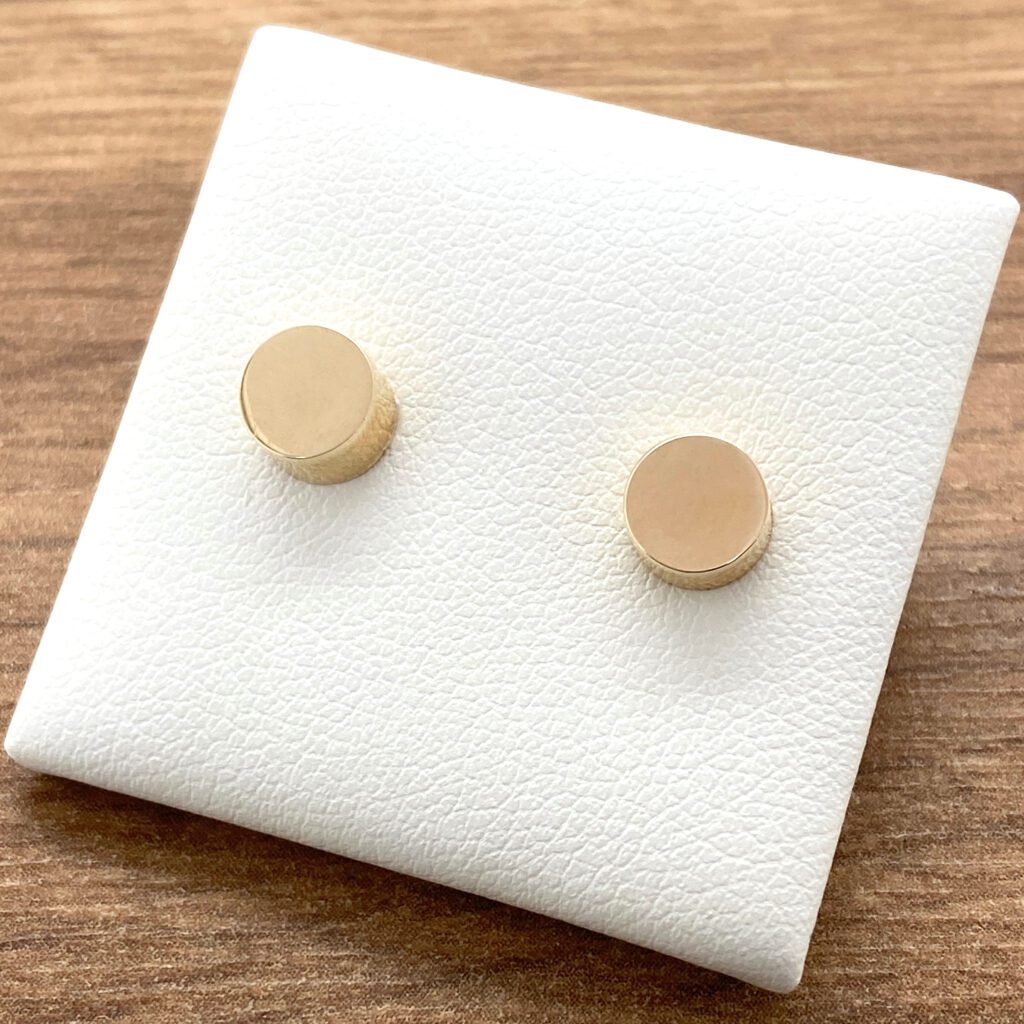 Gold circle stud earrings on display.