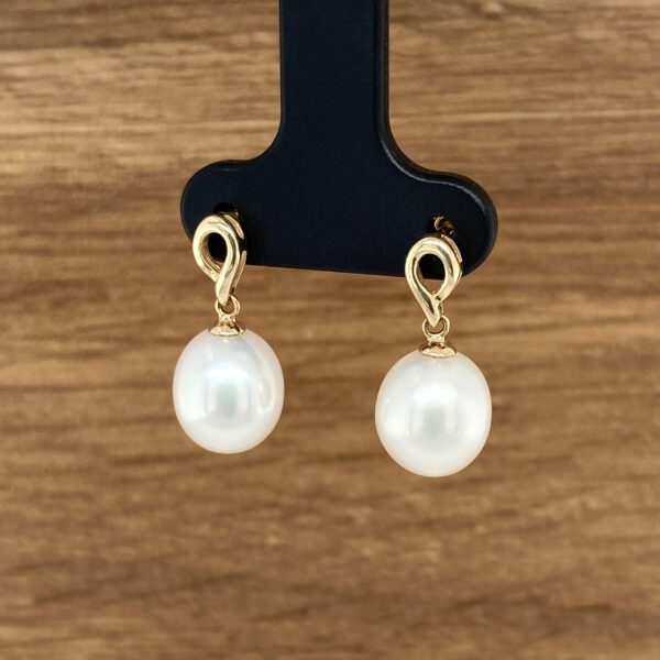 Elegant pearl and gold drop earrings.