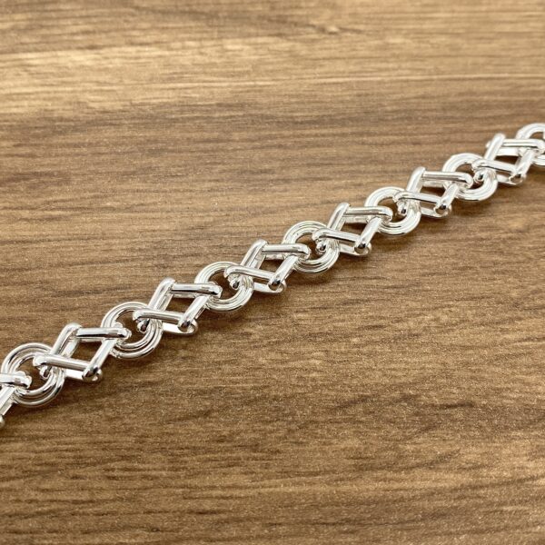 Silver chain link bracelet on wood.