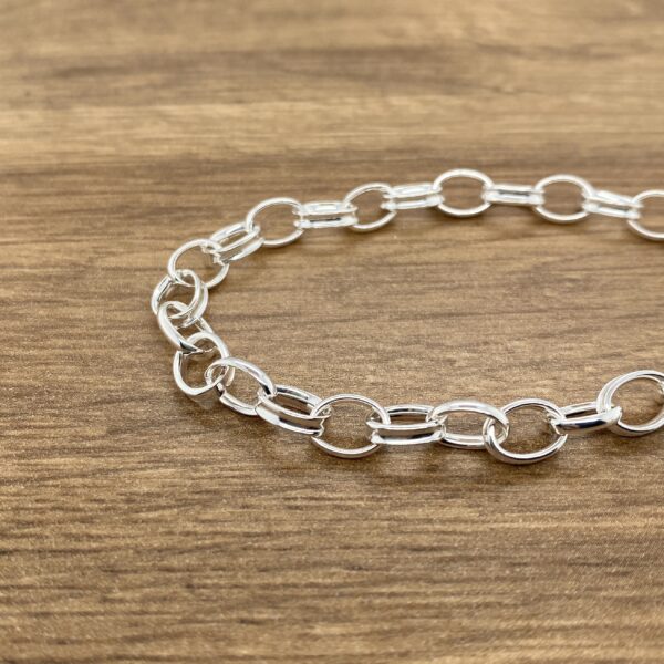 Silver chain bracelet on wood.