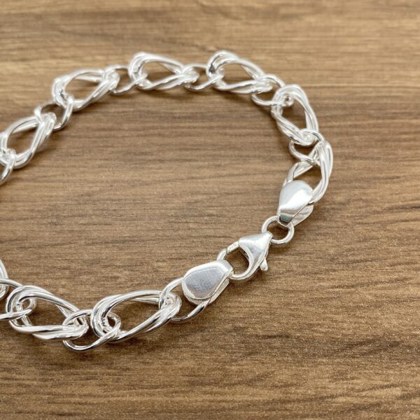 Silver chain link bracelet on wood.