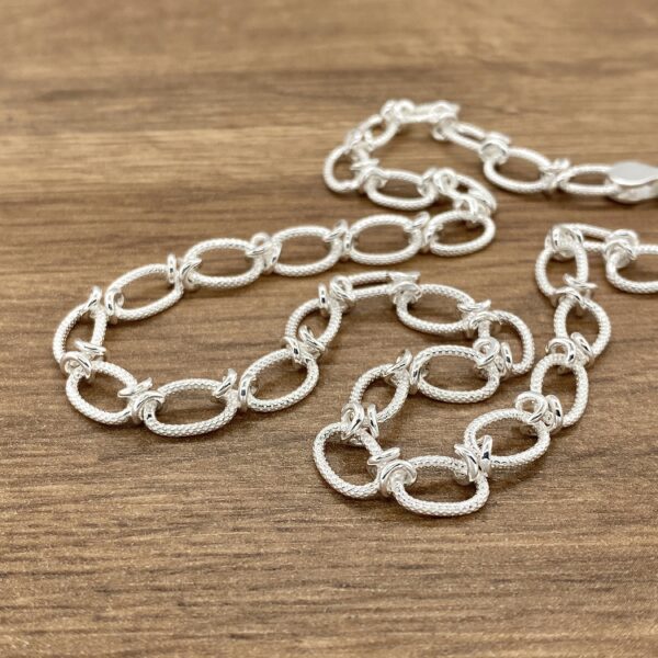 Silver textured oval link necklace.