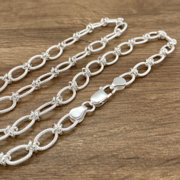 Silver chain necklace with knots.