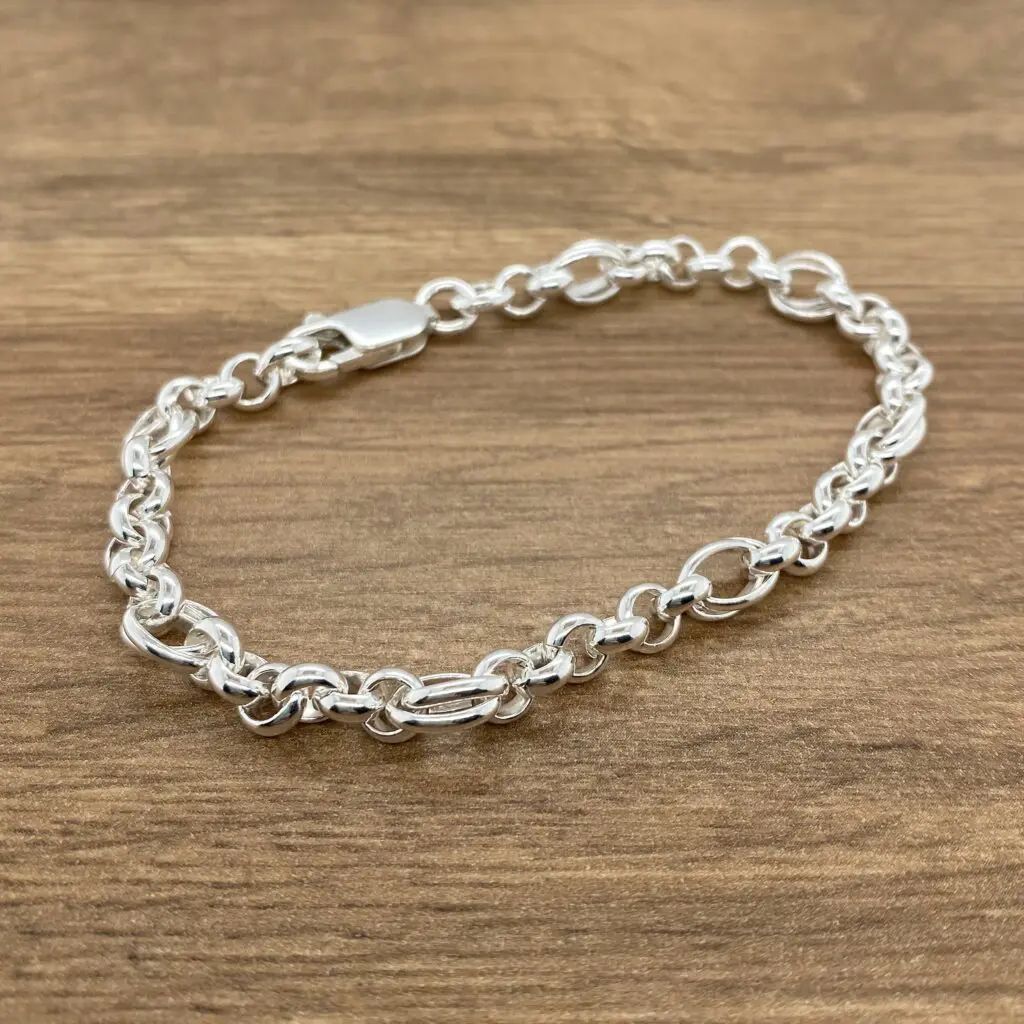 Silver chain bracelet on wood background.