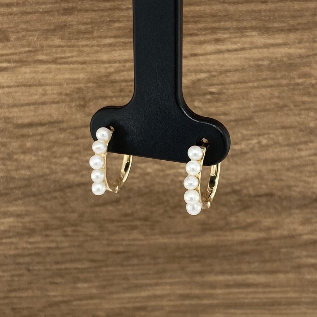 Gold pearl hoop earrings.